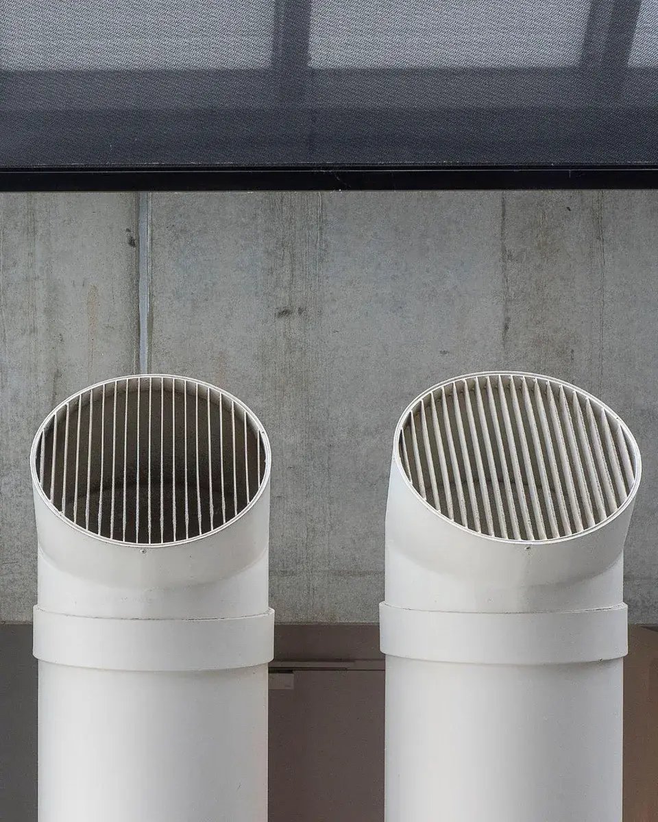 Two white ventilation outlets in front of a concrete wall, representing the indoor air quality market